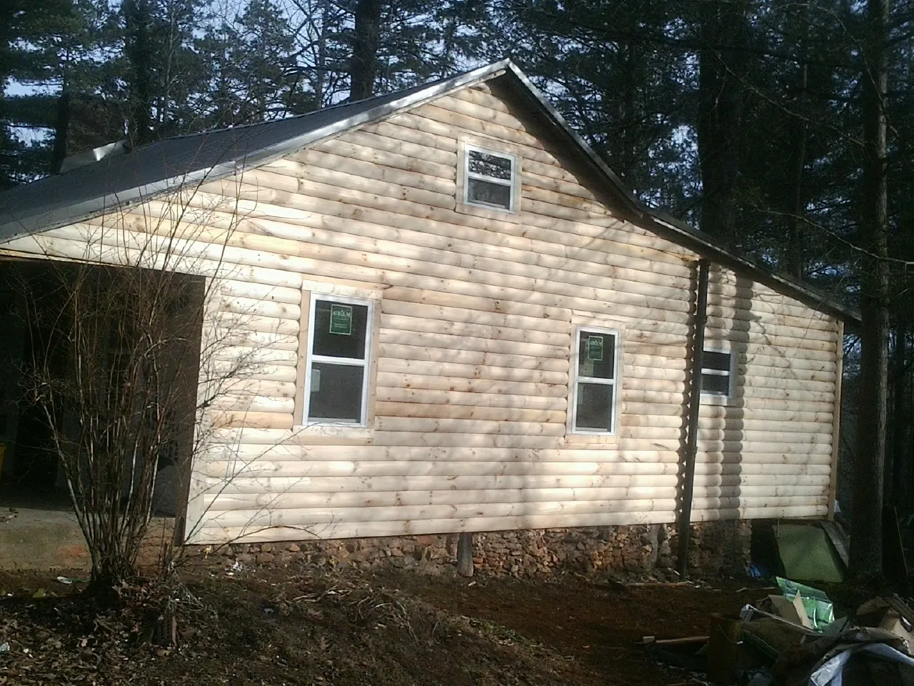 New log siding and dark metal roofing on a gable end in Springboro