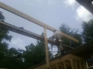 Carpenter setting a ridge beam over a new addition frame — Ice Dam Removal by Roofing Brothers in Springboro