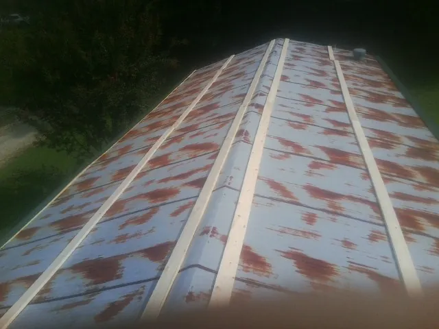 Rusted metal roof panels with new wood purlins before replacement — Storm Damage Roof Repair in Springboro by Roofing Brothers