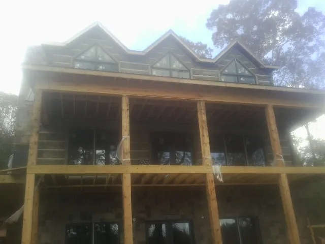 Dormers and porch framing on a large log home under construction — Roof Coating work by our crew in Springboro