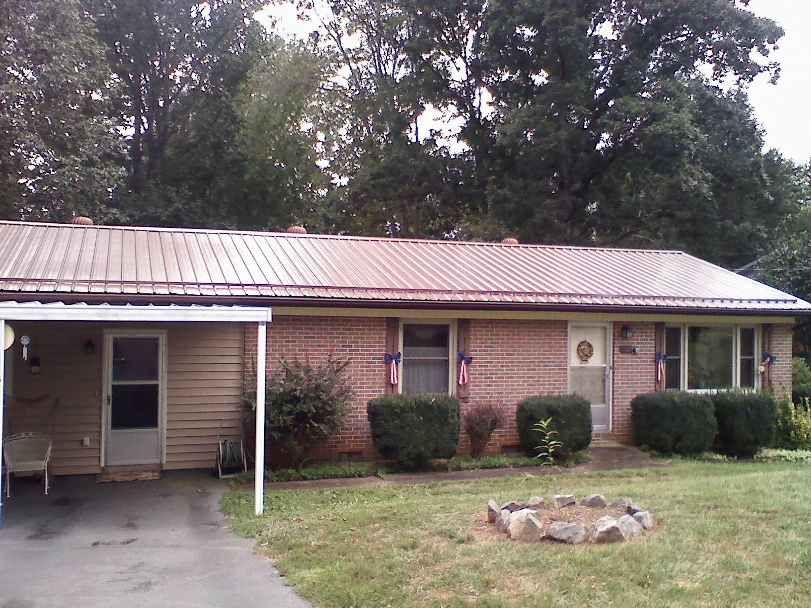Bronze metal roof and carport on a brick ranch home — Roof Repair work by our crew in Springboro